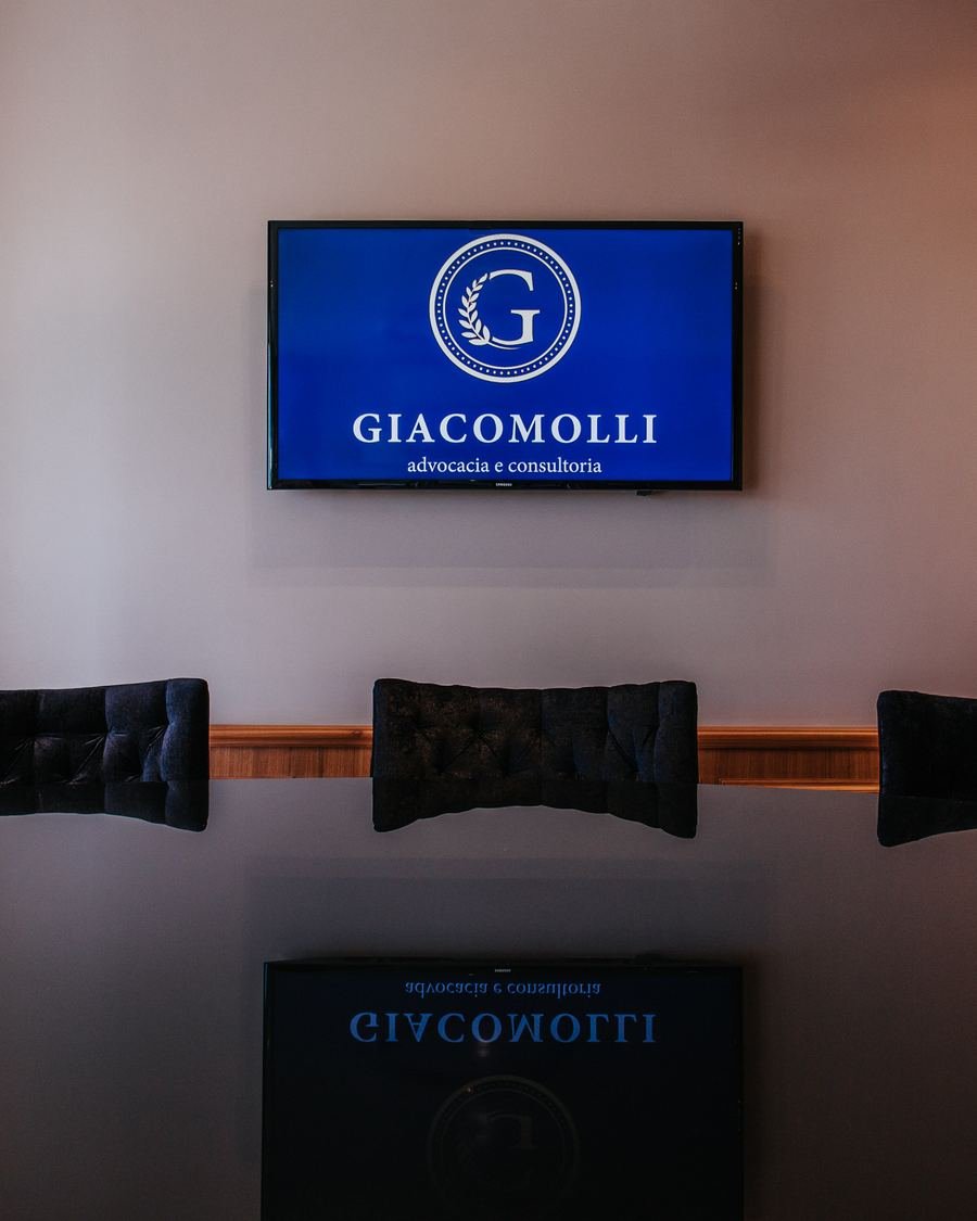 Sala de reuniões do escritório Giacomolli Advocacia e Consultoria em Porto Alegre, com a marca exibida na parede